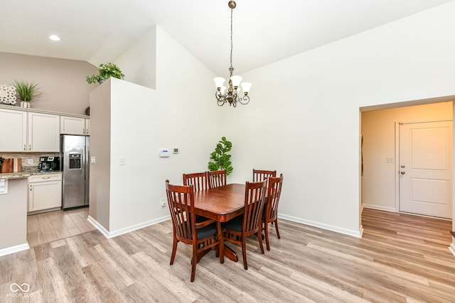 5765 White Pine Rd, Whitestown, IN 46075 - dining room with light wood finished floors, high vaulted ceiling, and a chandelier