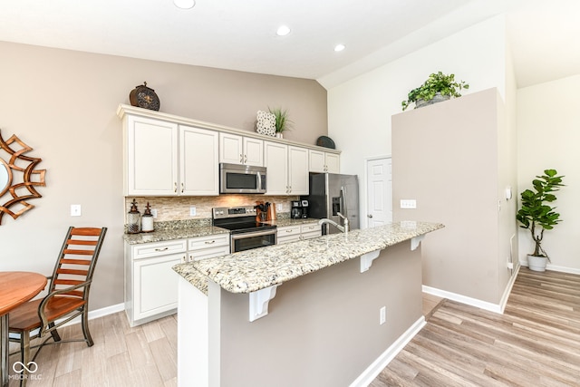 5765 White Pine Rd, Whitestown, IN 46075 - kitchen with stainless steel appliances, high vaulted ceiling, an island with sink, backsplash, and a breakfast bar