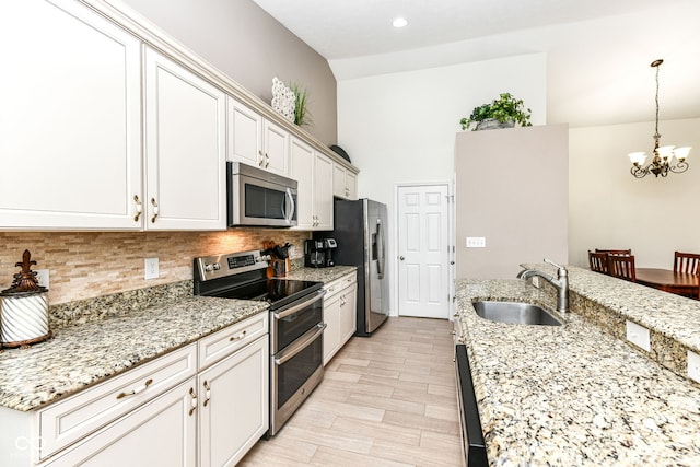 5765 White Pine Rd, Whitestown, IN 46075 - kitchen with appliances with stainless steel finishes, a chandelier, decorative backsplash, decorative light fixtures, and light stone countertops
