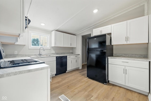 212 N 13th St, Elwood, IN 46036 - kitchen featuring black appliances, lofted ceiling, white cabinetry, light countertops, and light wood-style floors