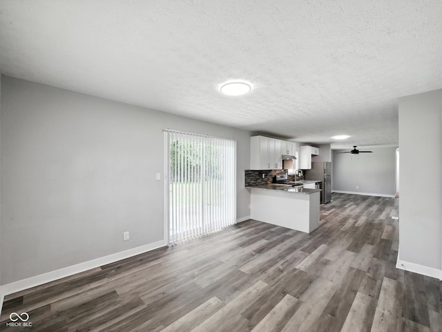 2853 S State Ave, Indianapolis, IN 46203 - unfurnished living room featuring dark wood-type flooring, a textured ceiling, and ceiling fan