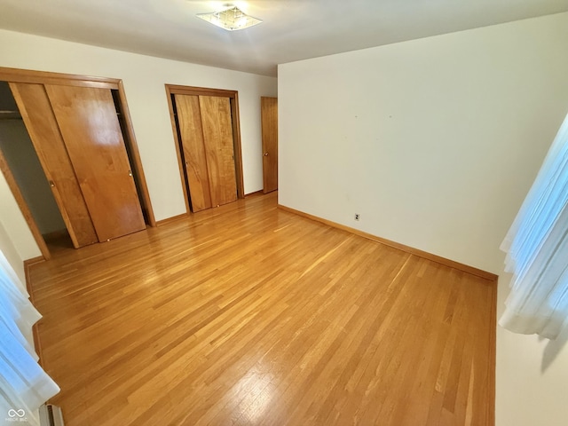 605 Redding Rd, Seymour, IN 47274 - unfurnished bedroom featuring light wood-style floors and multiple closets