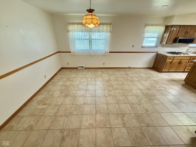 605 Redding Rd, Seymour, IN 47274 - kitchen featuring stainless steel appliances, light countertops, pendant lighting, and brown cabinetry