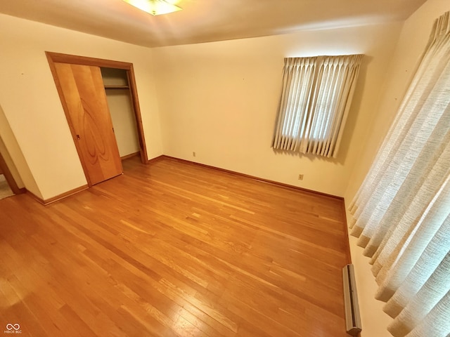 605 Redding Rd, Seymour, IN 47274 - unfurnished bedroom with light wood finished floors, baseboard heating, and a closet
