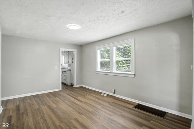 3609 N Keystone Ave, Indianapolis, IN 46218 - unfurnished bedroom featuring dark wood-style flooring and a textured ceiling