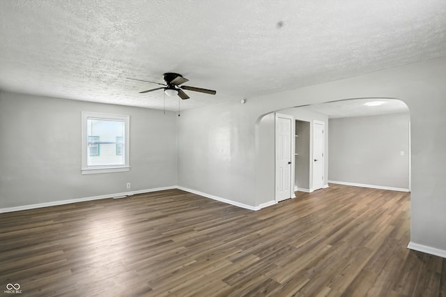 3609 N Keystone Ave, Indianapolis, IN 46218 - unfurnished room featuring arched walkways, a textured ceiling, dark wood-style flooring, and a ceiling fan