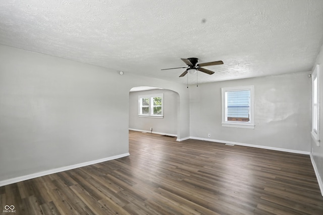 3609 N Keystone Ave, Indianapolis, IN 46218 - empty room featuring arched walkways, a textured ceiling, dark wood finished floors, and ceiling fan