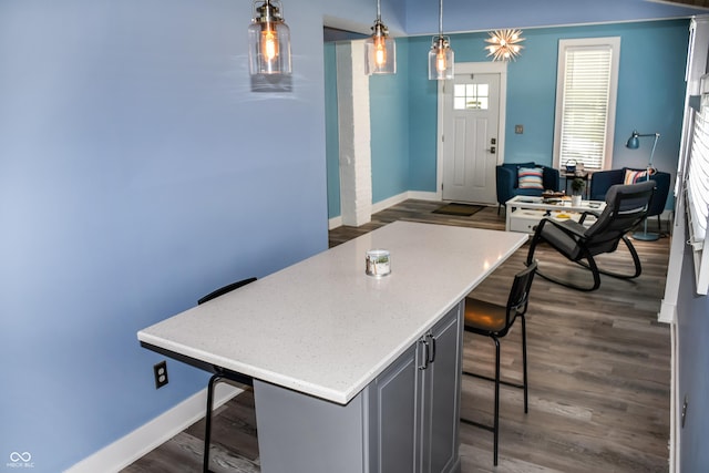 206 Olive St, Arcadia, IN 46030 - kitchen featuring a breakfast bar, dark wood-style floors, an office area, a kitchen island, and hanging light fixtures