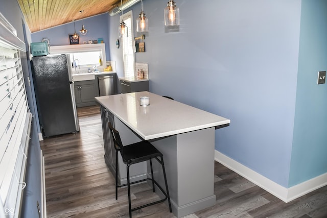 206 Olive St, Arcadia, IN 46030 - kitchen featuring appliances with stainless steel finishes, wood ceiling, dark wood-style floors, light countertops, and a center island