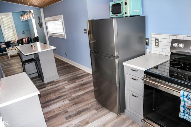 206 Olive St, Arcadia, IN 46030 - kitchen with stainless steel appliances, light wood-style flooring, tasteful backsplash, light countertops, and wooden ceiling