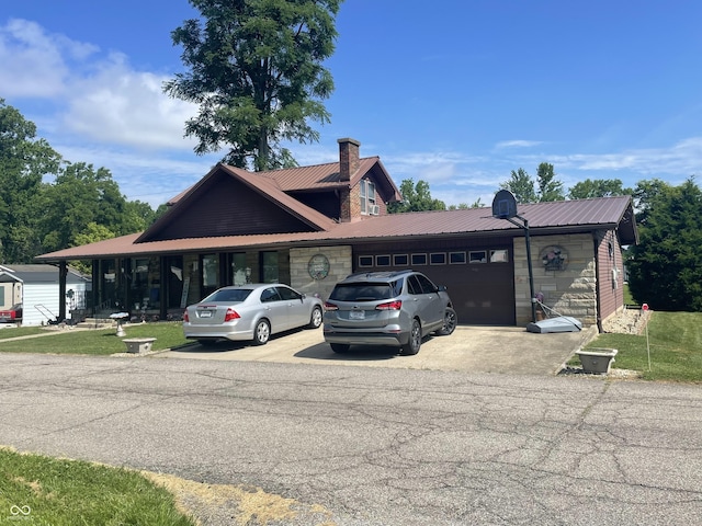100 Durbin St, North Vernon, IN 47265 - view of front of house featuring a garage, a metal roof, driveway, a front yard, and a chimney