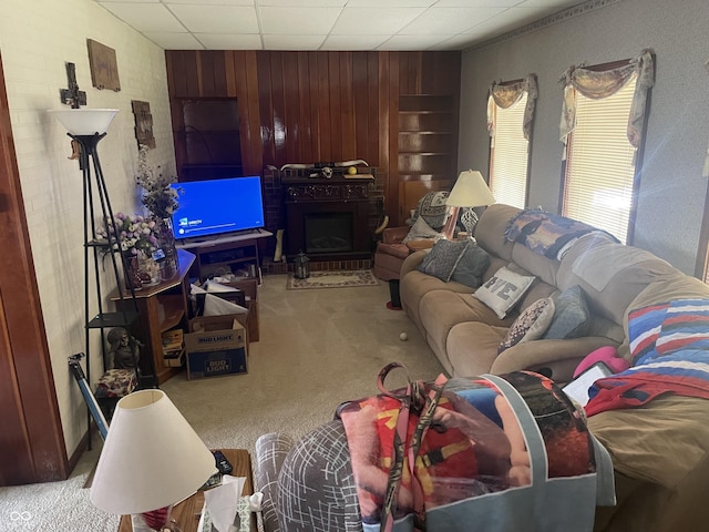 100 Durbin St, North Vernon, IN 47265 - carpeted living room featuring wooden walls and a fireplace