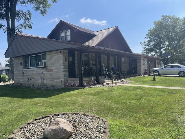 100 Durbin St, North Vernon, IN 47265 - view of home's exterior featuring a yard, stone siding, a metal roof, and a porch