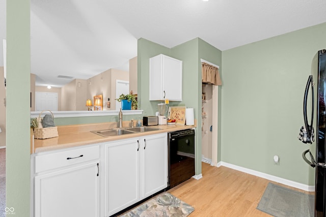 1912 Blue Pine Ln, Indianapolis, IN 46231 - kitchen featuring black appliances, light wood-type flooring, white cabinets, and light countertops
