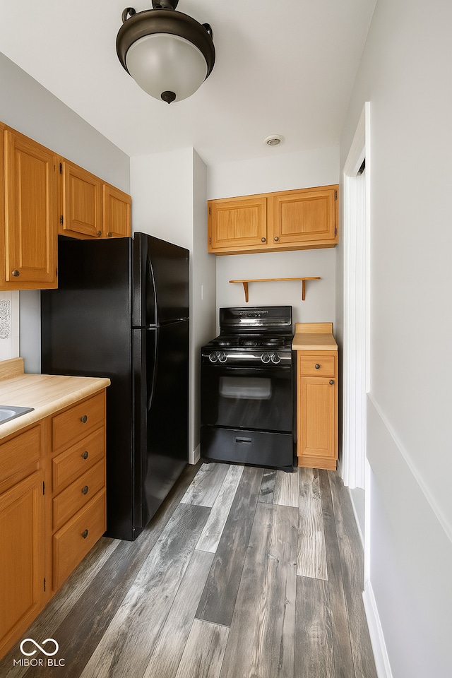 3642 N Dequincy St, Indianapolis, IN 46218 - kitchen featuring black appliances, dark wood-style flooring, and light countertops