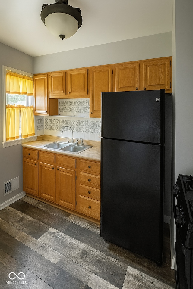 3642 N Dequincy St, Indianapolis, IN 46218 - kitchen featuring freestanding refrigerator, stove, light countertops, dark wood-type flooring, and tasteful backsplash