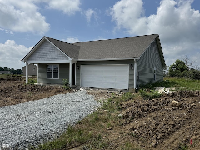 1063 Lake Ct, Shirley, IN 47384 - view of front facade with an attached garage, gravel driveway, a shingled roof, and a porch