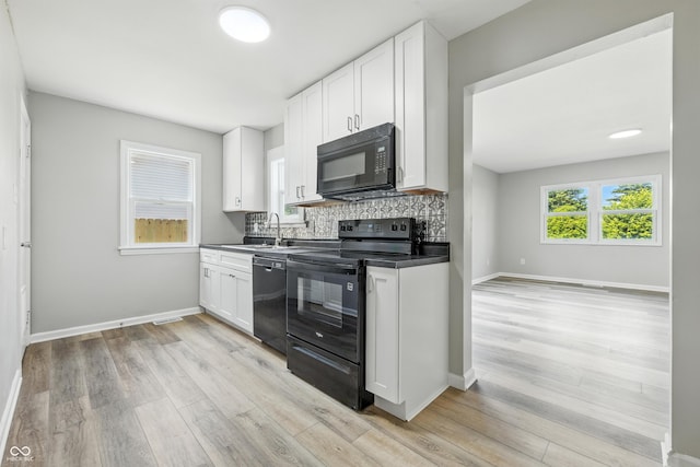 452 N Fenton Ave, Indianapolis, IN 46219 - kitchen featuring black appliances, tasteful backsplash, white cabinetry, light wood finished floors, and dark countertops