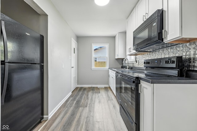 452 N Fenton Ave, Indianapolis, IN 46219 - kitchen with black appliances, light wood-type flooring, white cabinetry, decorative backsplash, and dark countertops
