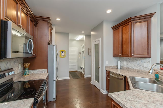 1976 Austin James Ln, Seymour, IN 47274 - kitchen with appliances with stainless steel finishes, light countertops, dark wood-type flooring, backsplash, and recessed lighting