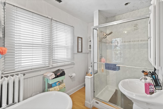 38 W Main St, Brownsburg, IN 46112 - full bath with a stall shower, healthy amount of natural light, radiator, wood finished floors, and wainscoting