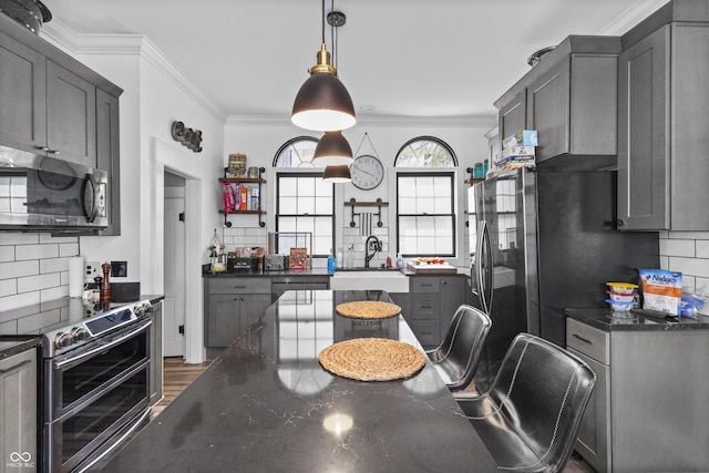 38 W Main St, Brownsburg, IN 46112 - kitchen featuring stainless steel appliances, backsplash, crown molding, gray cabinets, and hanging light fixtures