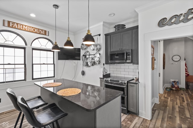 38 W Main St, Brownsburg, IN 46112 - kitchen with stainless steel appliances, backsplash, a center island, crown molding, and wood finished floors