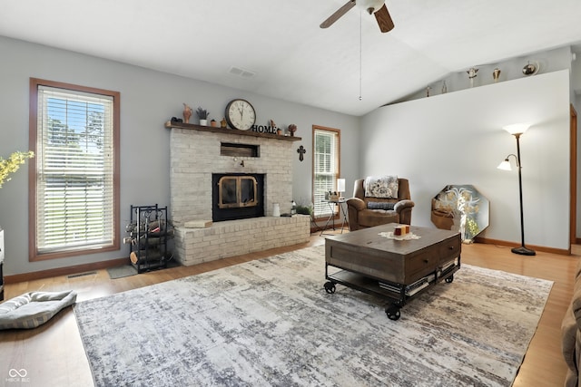 1346 N Buck Creek Rd, Greenfield, IN 46140 - living room with vaulted ceiling, wood finished floors, a ceiling fan, and a brick fireplace