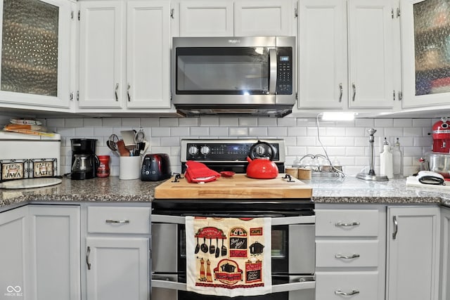 1346 N Buck Creek Rd, Greenfield, IN 46140 - kitchen with stainless steel appliances, white cabinets, decorative backsplash, and glass insert cabinets
