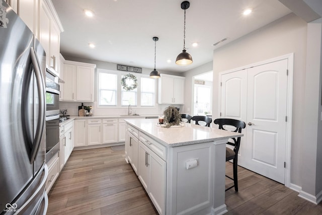 2856 Old Rosebud Ln, Westfield, IN 46074 - kitchen with appliances with stainless steel finishes, a breakfast bar area, recessed lighting, a center island, and light wood-type flooring
