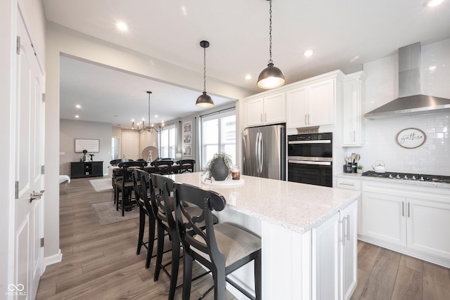 2856 Old Rosebud Ln, Westfield, IN 46074 - kitchen with stainless steel appliances, wall chimney exhaust hood, a center island, backsplash, and white cabinets