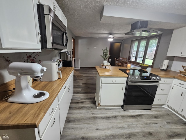 2239 Chevelle Ct, Anderson, IN 46012 - kitchen featuring appliances with stainless steel finishes, butcher block countertops, a textured ceiling, radiator heating unit, and light wood-type flooring