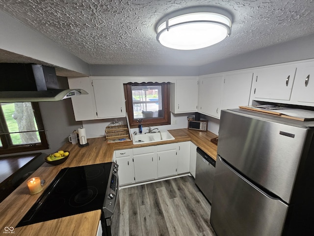 2239 Chevelle Ct, Anderson, IN 46012 - kitchen with appliances with stainless steel finishes, ventilation hood, wooden counters, a textured ceiling, and wood finished floors