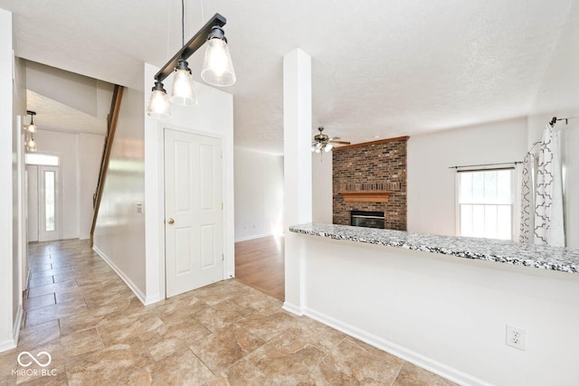 8909 Carnation Dr, Noblesville, IN 46060 - unfurnished living room featuring ceiling fan, a fireplace, and a textured ceiling