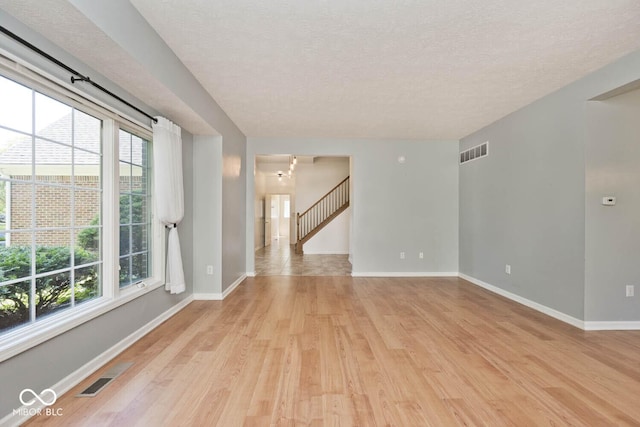 8909 Carnation Dr, Noblesville, IN 46060 - unfurnished room with light wood-type flooring, plenty of natural light, and a textured ceiling