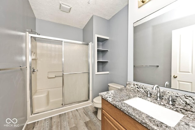 8909 Carnation Dr, Noblesville, IN 46060 - bathroom with wood finished floors, a stall shower, vanity, and a textured ceiling