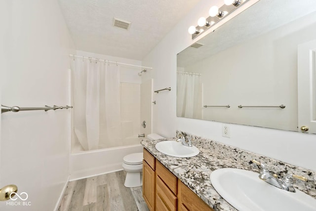 8909 Carnation Dr, Noblesville, IN 46060 - full bath with wood finished floors, double vanity, shower / bath combination with curtain, and a textured ceiling
