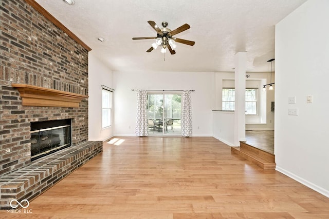 8909 Carnation Dr, Noblesville, IN 46060 - unfurnished living room featuring wood finished floors, a ceiling fan, and a brick fireplace