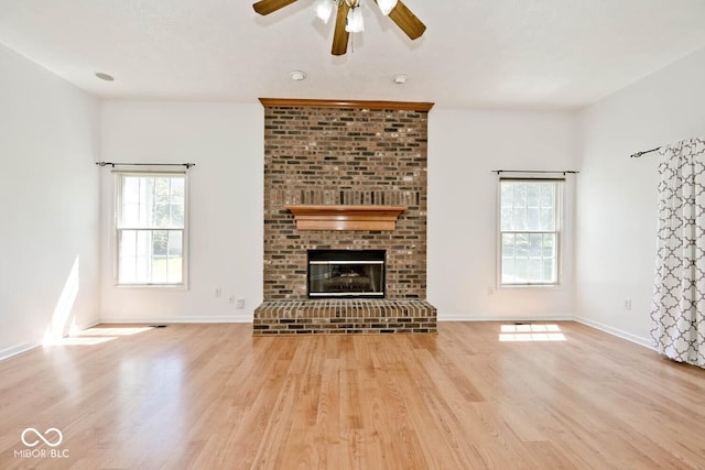 8909 Carnation Dr, Noblesville, IN 46060 - unfurnished living room featuring wood finished floors, ceiling fan, and a brick fireplace