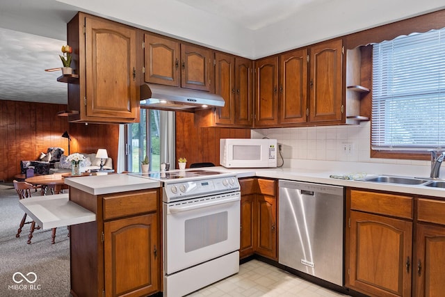 3620 Winter St, Lafayette, IN 47909 - kitchen featuring white appliances, under cabinet range hood, healthy amount of natural light, light countertops, and wooden walls
