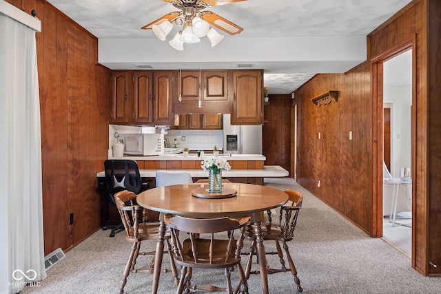 3620 Winter St, Lafayette, IN 47909 - dining room featuring light carpet, wood walls, and a ceiling fan