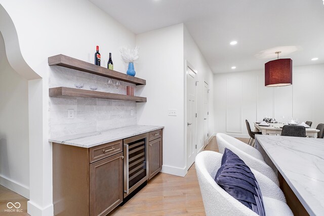 2130 Brookside Pkwy N Drive, Indianapolis, IN 46201 - indoor dry bar featuring wine cooler, light wood-type flooring, recessed lighting, decorative backsplash, and pendant lighting