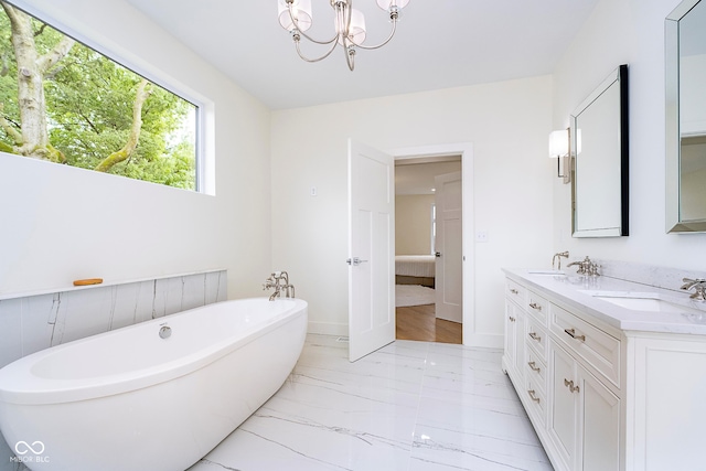 2130 Brookside Pkwy N Drive, Indianapolis, IN 46201 - bathroom featuring a freestanding bath, marble look tiles, double vanity, and a chandelier