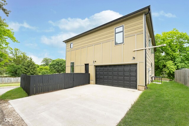 2130 Brookside Pkwy N Drive, Indianapolis, IN 46201 - view of home's exterior with an attached garage, concrete driveway, and board and batten siding