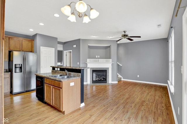 5674 Brownstone Dr, Indianapolis, IN 46220 - kitchen featuring stainless steel fridge, a chandelier, light wood finished floors, dishwasher, and a kitchen island with sink