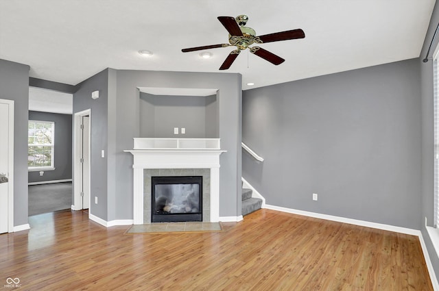 5674 Brownstone Dr, Indianapolis, IN 46220 - unfurnished living room featuring a ceiling fan, wood finished floors, stairway, and a fireplace