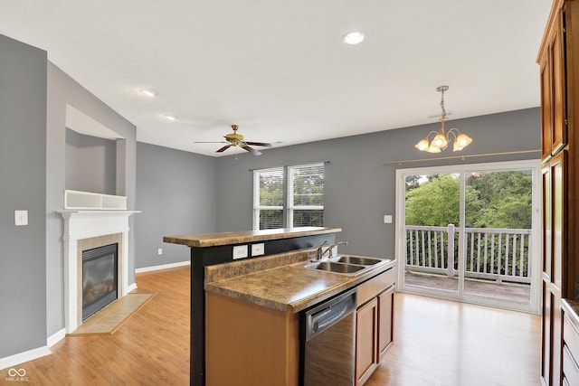 5674 Brownstone Dr, Indianapolis, IN 46220 - kitchen with dishwashing machine, light wood finished floors, a tile fireplace, brown cabinets, and recessed lighting