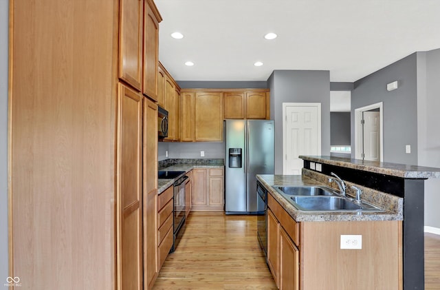 5674 Brownstone Dr, Indianapolis, IN 46220 - kitchen with black appliances, a kitchen island with sink, light wood finished floors, and recessed lighting