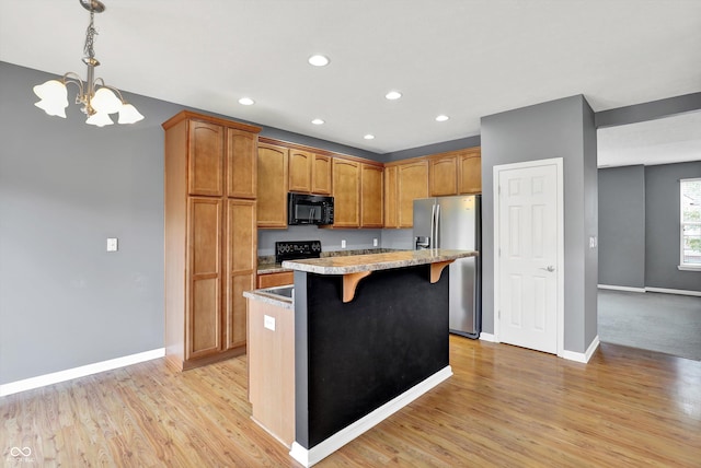 5674 Brownstone Dr, Indianapolis, IN 46220 - kitchen featuring black microwave, stainless steel fridge, a chandelier, a kitchen breakfast bar, and recessed lighting