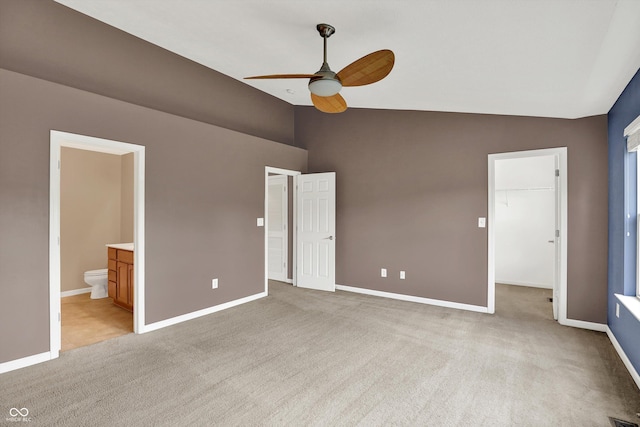 5674 Brownstone Dr, Indianapolis, IN 46220 - unfurnished bedroom featuring light colored carpet, a walk in closet, connected bathroom, high vaulted ceiling, and ceiling fan